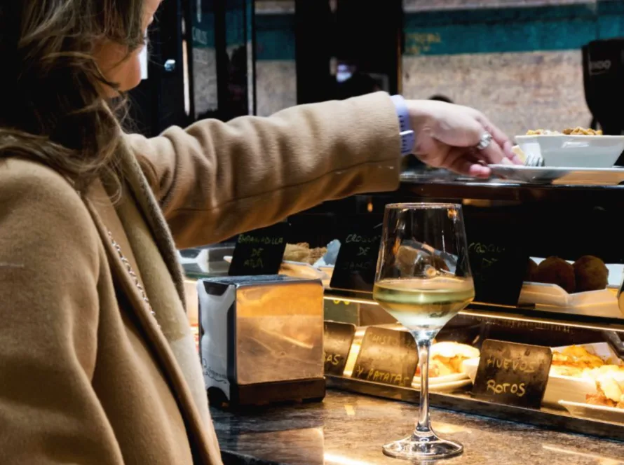Mujer comiendo tapas en la barra de cayros